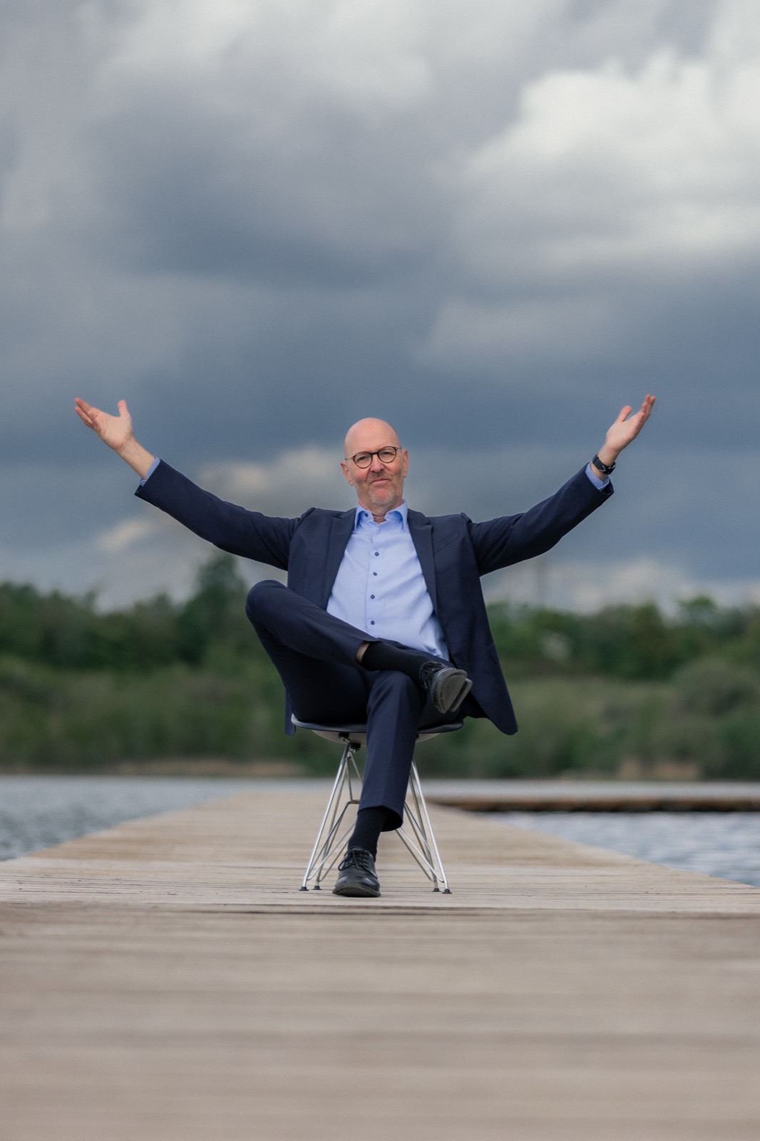 Per Beining sitting on a jetty with his arms spread wide in welcome